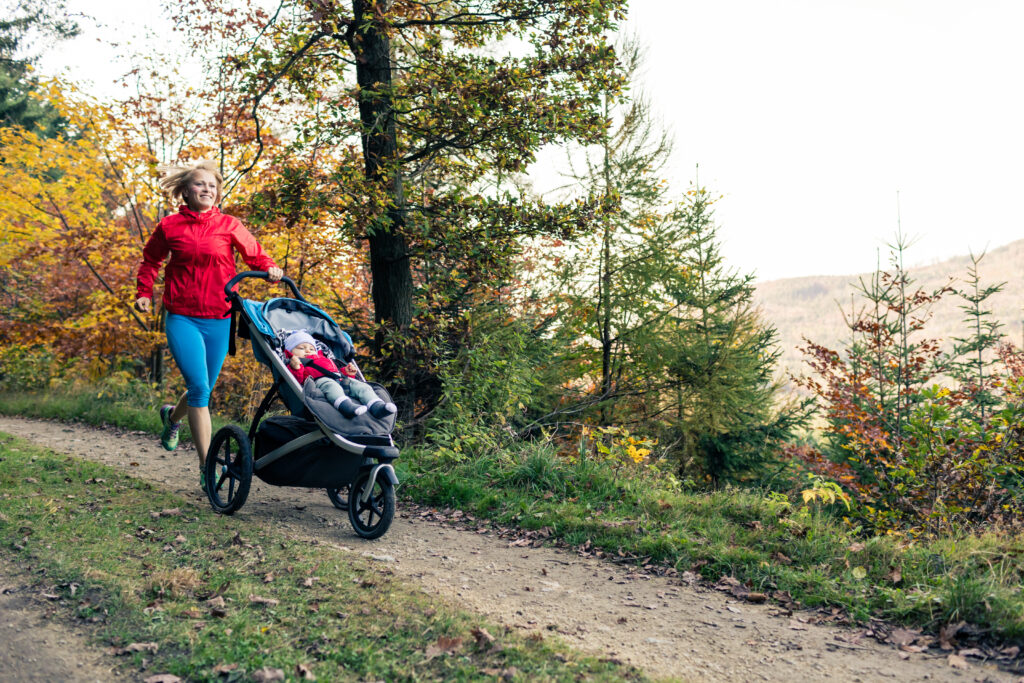 
En mor på joggetur med et barn i barnevogn